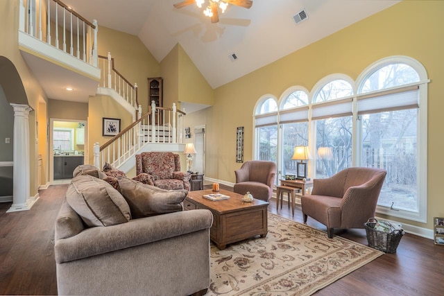 living room with high vaulted ceiling, dark wood-type flooring, decorative columns, and ceiling fan