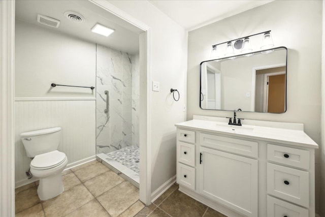 bathroom featuring vanity, tiled shower, and toilet