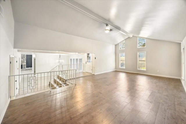 unfurnished living room with a notable chandelier, beam ceiling, dark wood-type flooring, and high vaulted ceiling