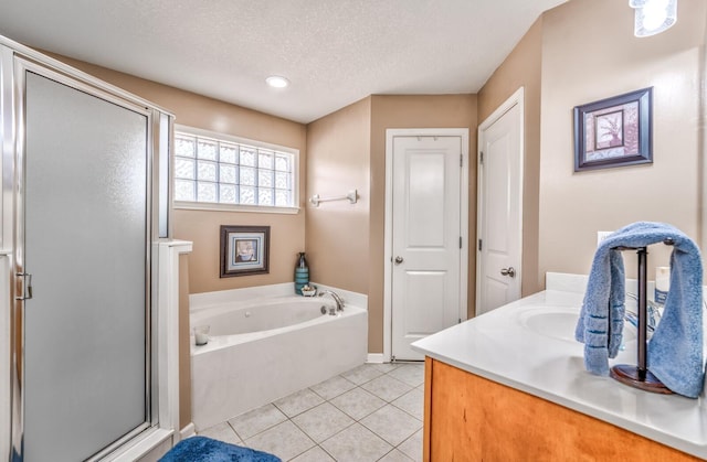 bathroom featuring vanity, tile patterned floors, shower with separate bathtub, and a textured ceiling