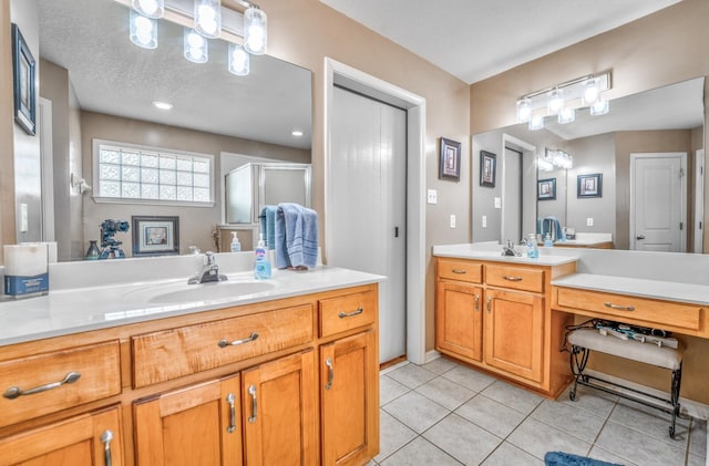 bathroom with tile patterned floors, a shower with shower door, and vanity