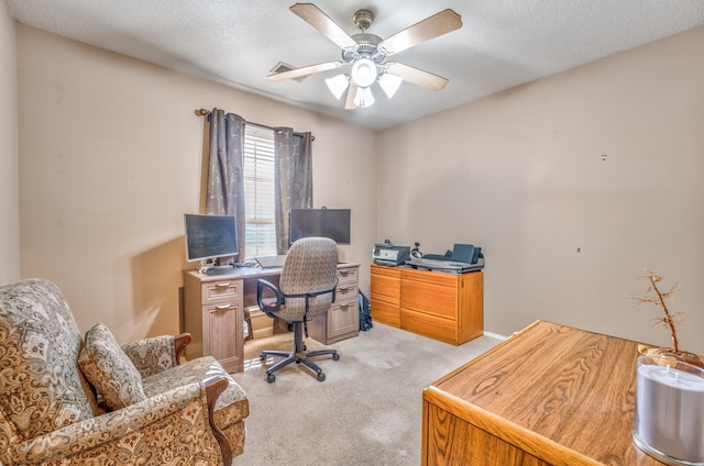 carpeted office space with ceiling fan and a textured ceiling