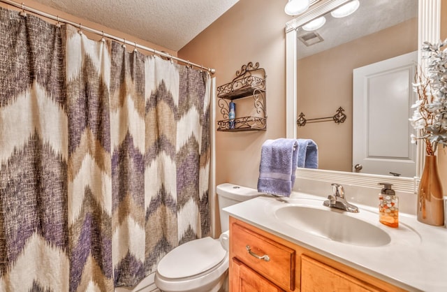 bathroom with a shower with curtain, vanity, a textured ceiling, and toilet