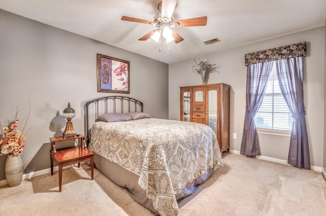 carpeted bedroom featuring ceiling fan and a textured ceiling