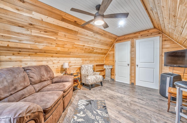 living room with hardwood / wood-style flooring, ceiling fan, vaulted ceiling, wooden ceiling, and wood walls