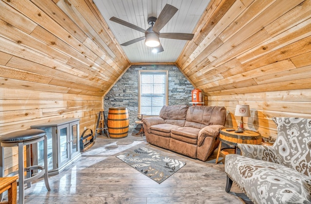 living room with hardwood / wood-style flooring, vaulted ceiling, wooden ceiling, and wood walls