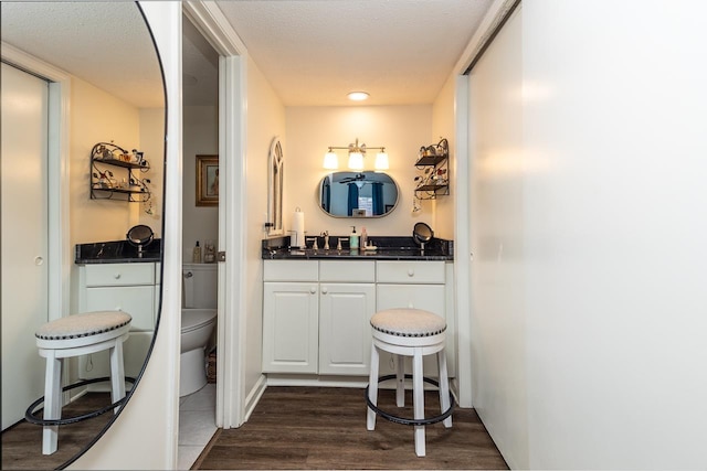 bathroom featuring hardwood / wood-style flooring, vanity, and toilet