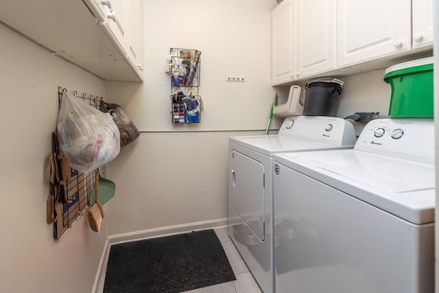 clothes washing area featuring cabinets, separate washer and dryer, and light tile patterned floors