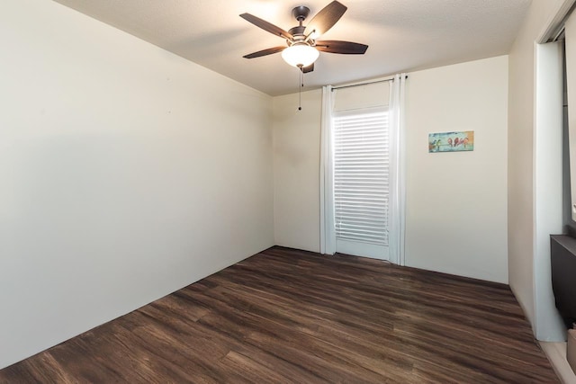 empty room featuring ceiling fan, dark hardwood / wood-style floors, and a textured ceiling