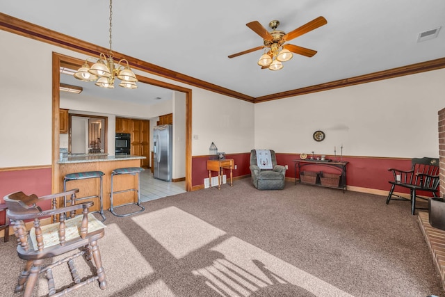 living room with crown molding, ceiling fan with notable chandelier, and light colored carpet