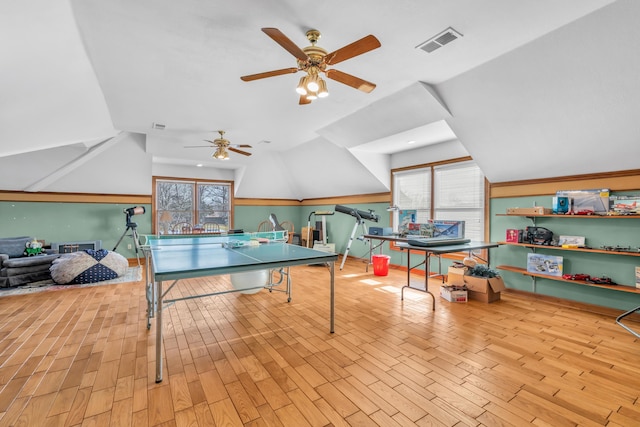 playroom with vaulted ceiling, a wealth of natural light, and light hardwood / wood-style flooring