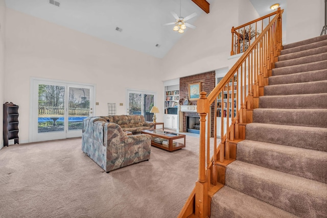 carpeted living room featuring beamed ceiling, ceiling fan, a fireplace, and high vaulted ceiling