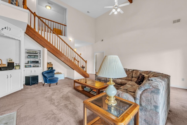 carpeted living room with a towering ceiling and ceiling fan