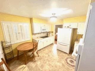 kitchen featuring white appliances and white cabinets