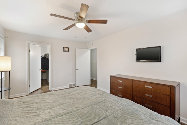 unfurnished bedroom featuring light carpet, a spacious closet, a closet, and ceiling fan