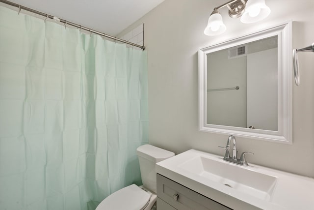 bathroom featuring vanity, toilet, and walk in shower