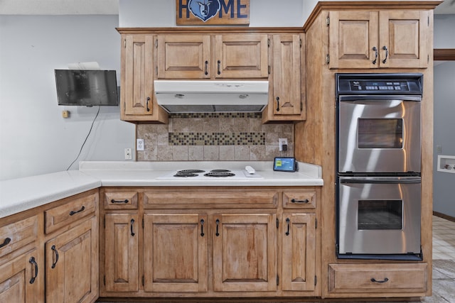 kitchen with white stovetop, backsplash, and stainless steel double oven