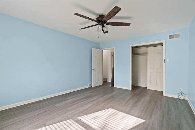 unfurnished bedroom featuring dark wood-type flooring, ceiling fan, and a closet