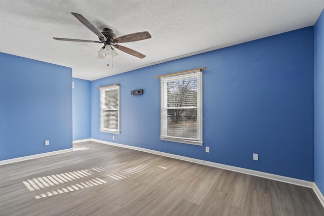 empty room with hardwood / wood-style flooring, a textured ceiling, and ceiling fan