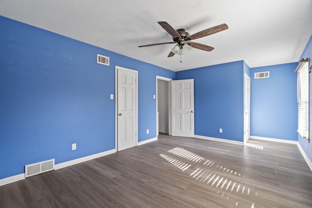 unfurnished bedroom with ceiling fan and dark hardwood / wood-style flooring