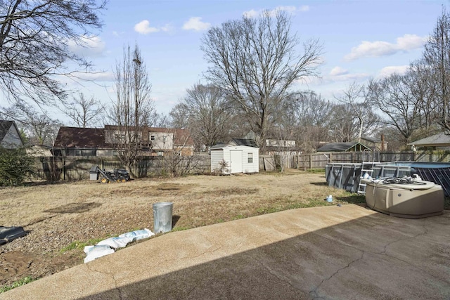 view of yard featuring a storage shed, a covered pool, and a patio