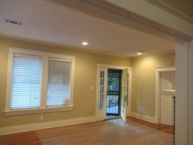 entryway with hardwood / wood-style floors and crown molding