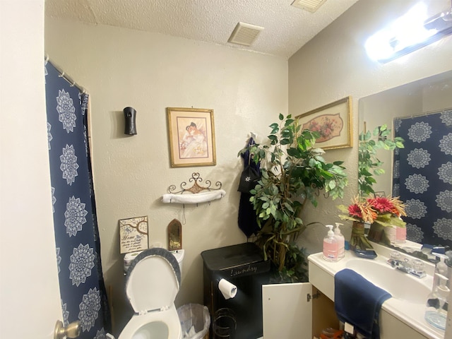 bathroom with sink, a textured ceiling, and toilet