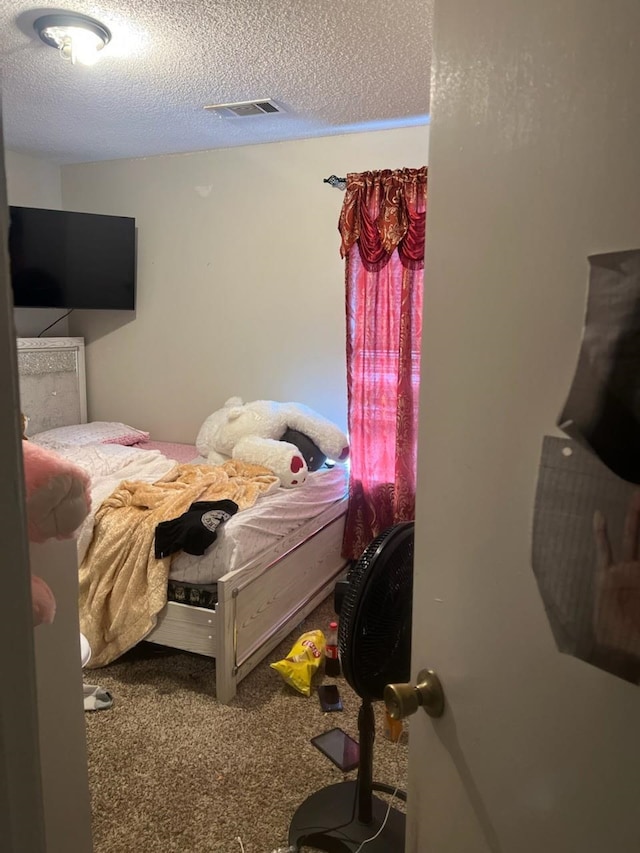 carpeted bedroom with a textured ceiling