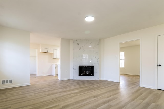 unfurnished living room featuring light hardwood / wood-style floors and a premium fireplace