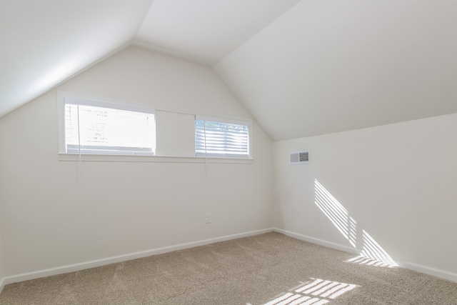 bonus room with lofted ceiling and carpet flooring