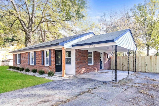 ranch-style home with a front yard and a carport