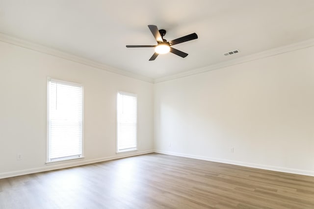 empty room with ceiling fan, ornamental molding, and light wood-type flooring