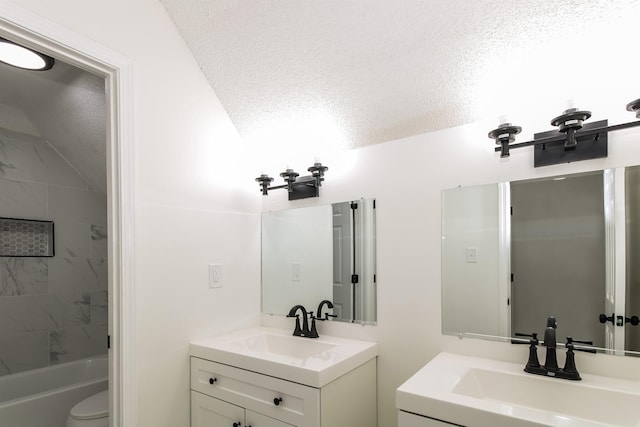 full bathroom with tiled shower / bath, vanity, toilet, and a textured ceiling