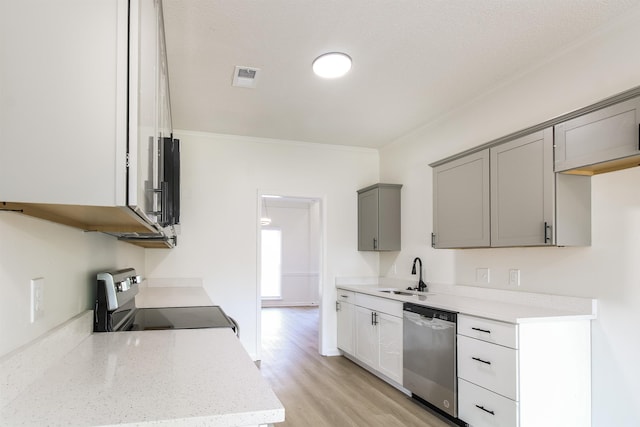 kitchen with sink, light hardwood / wood-style flooring, gray cabinetry, stainless steel appliances, and ornamental molding