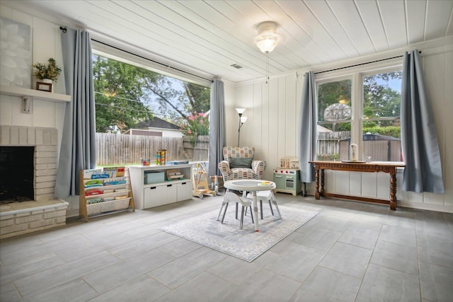 unfurnished room with a fireplace, a wealth of natural light, and wooden ceiling