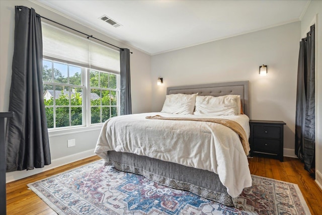 bedroom featuring dark wood-type flooring and ornamental molding