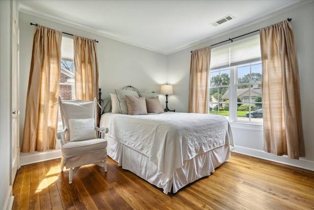 bedroom featuring ornamental molding and wood-type flooring