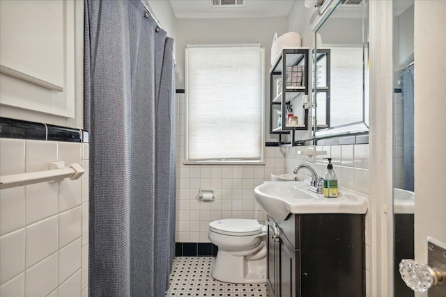 bathroom with tile patterned flooring, tile walls, vanity, a shower with curtain, and toilet