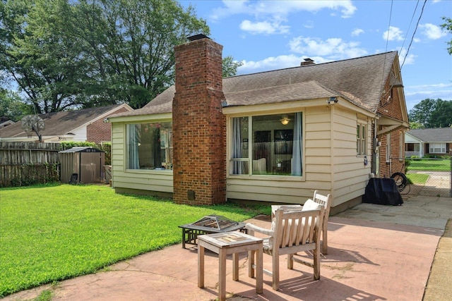 back of property featuring a yard, a fire pit, and a patio area