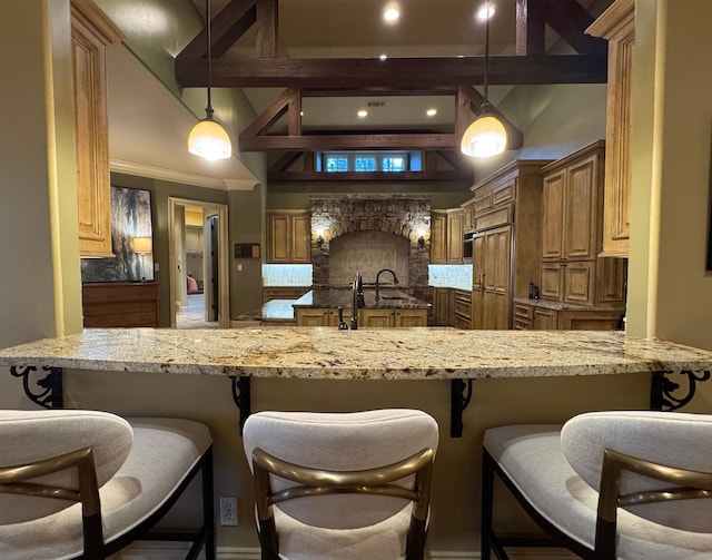 kitchen with tasteful backsplash, hanging light fixtures, and a kitchen bar