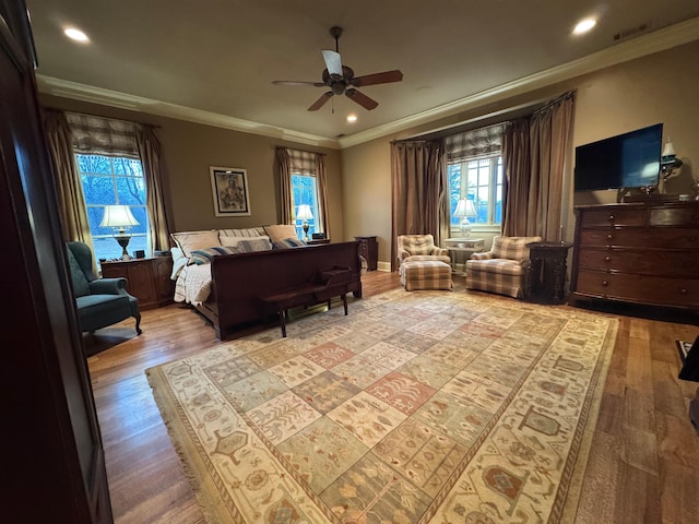 bedroom with ceiling fan, ornamental molding, and light hardwood / wood-style floors