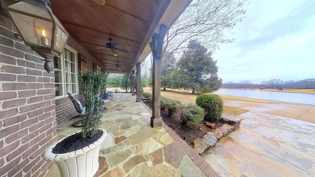 view of patio with a water view and ceiling fan