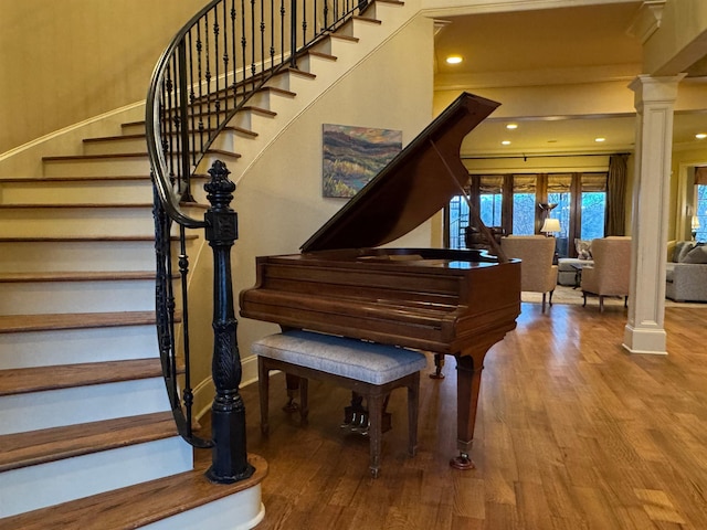 miscellaneous room featuring decorative columns and hardwood / wood-style flooring