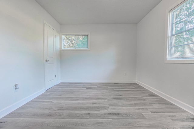 unfurnished room featuring a wealth of natural light and light hardwood / wood-style floors
