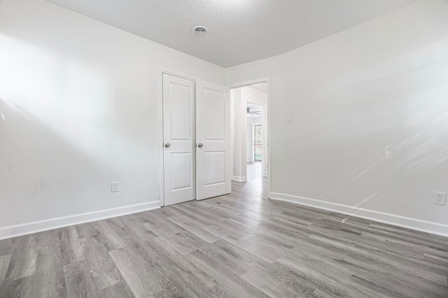spare room featuring hardwood / wood-style floors and a textured ceiling