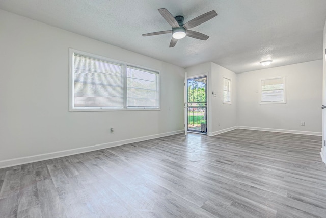 unfurnished room featuring ceiling fan, a textured ceiling, and light wood-type flooring