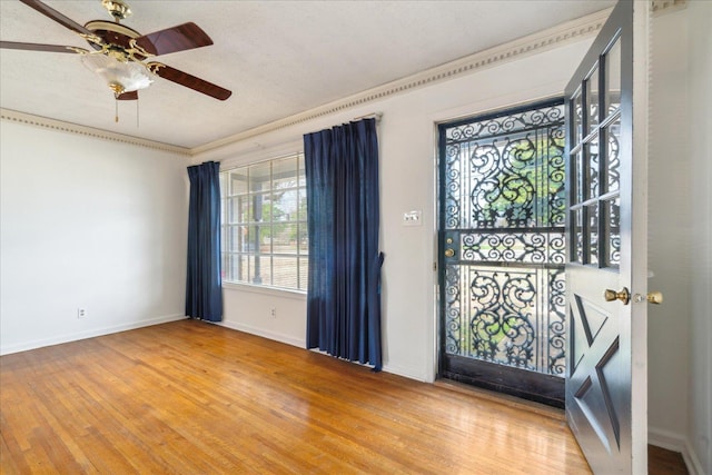 entryway with hardwood / wood-style flooring, ceiling fan, ornamental molding, and a textured ceiling