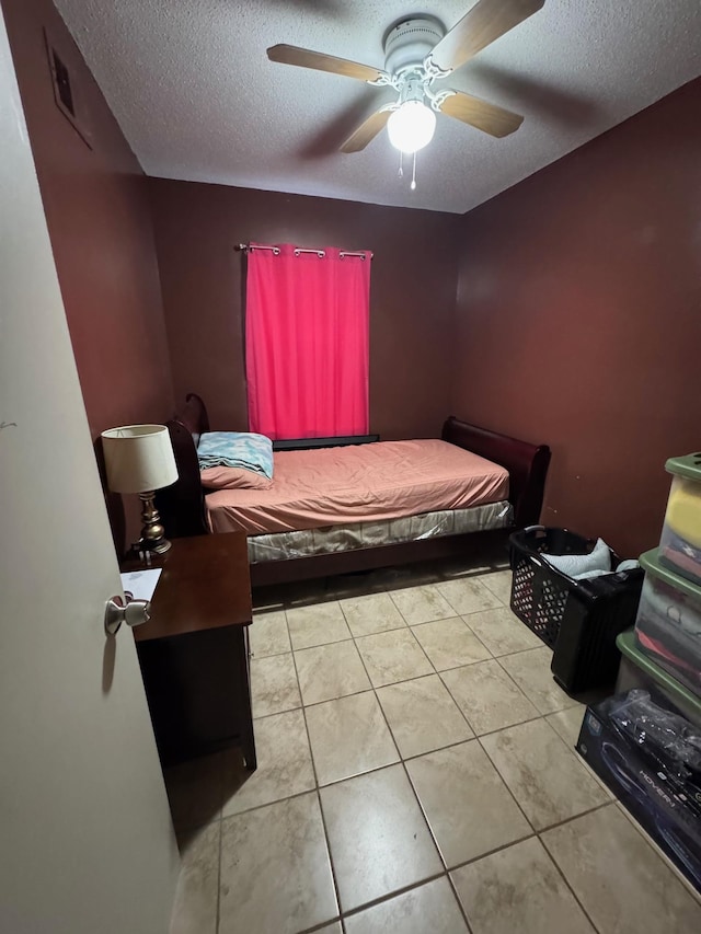 bedroom with light tile patterned flooring, ceiling fan, and a textured ceiling