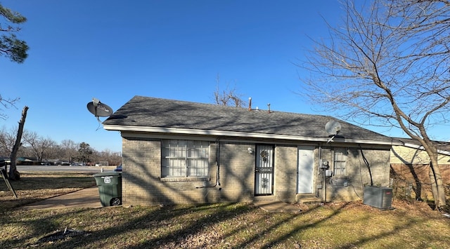 view of front of property featuring a front yard and central air condition unit