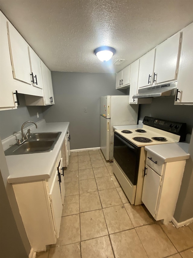 kitchen with sink, white appliances, light tile patterned floors, a textured ceiling, and white cabinets